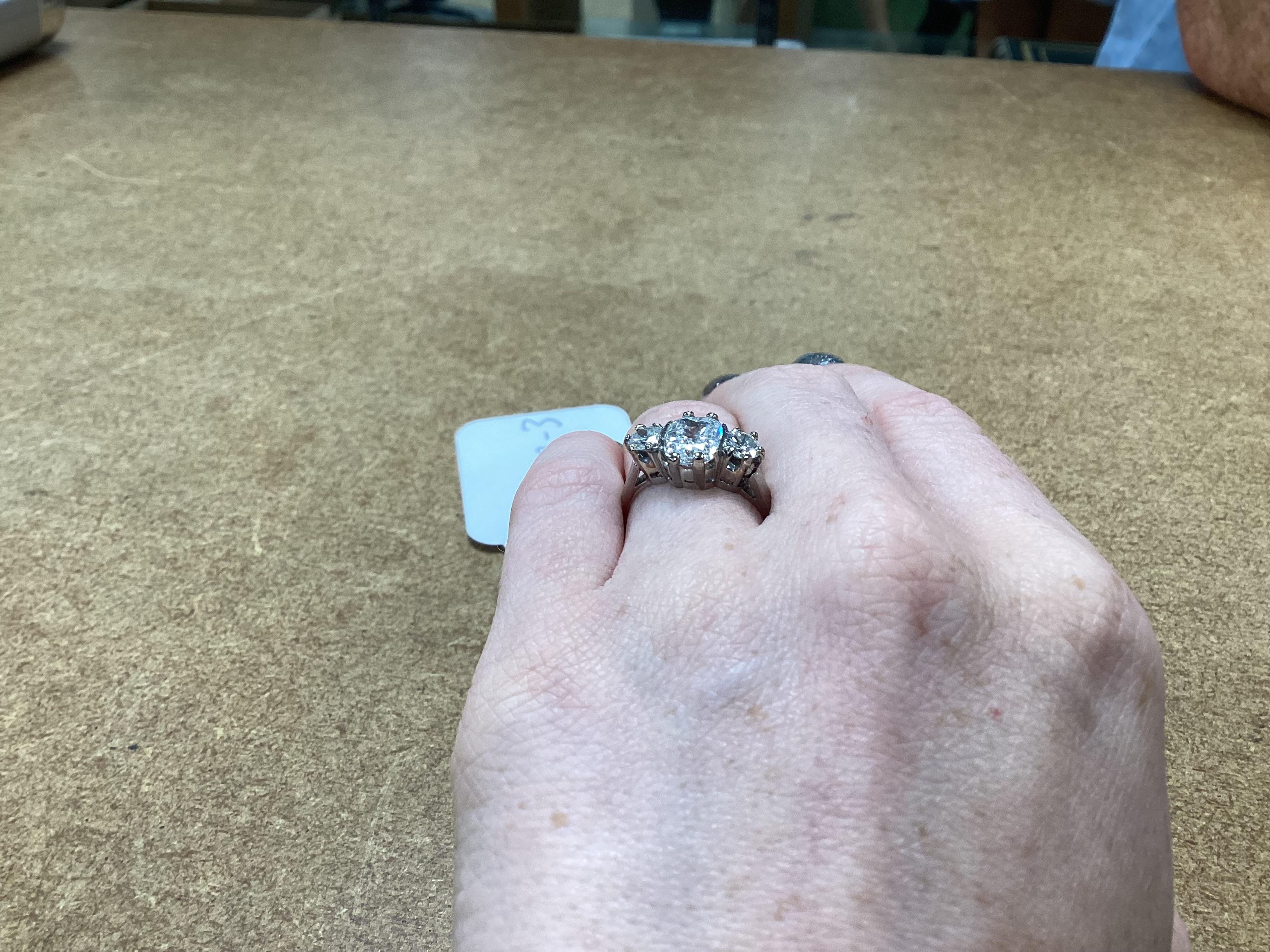 A diamond ring, set with a cushion-shaped diamond weighing 1.50 carats, between shoulders set with brilliant-cut diamonds totalling approximately 0.40 carats, size K, gross weight approximately 4 grams, Condition: centra